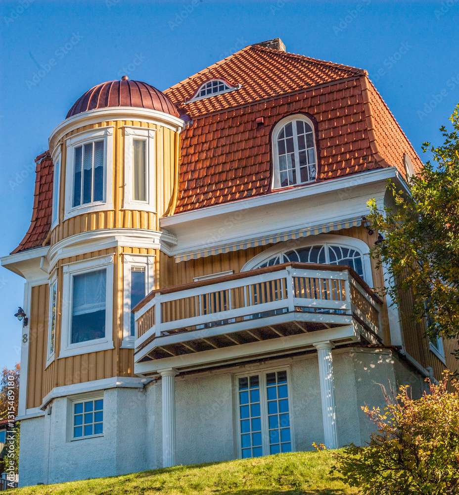 Obraz premium Facade of a yellow wooden house with creative architectural solutions.