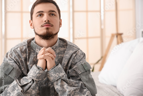 Young male soldier praying ...