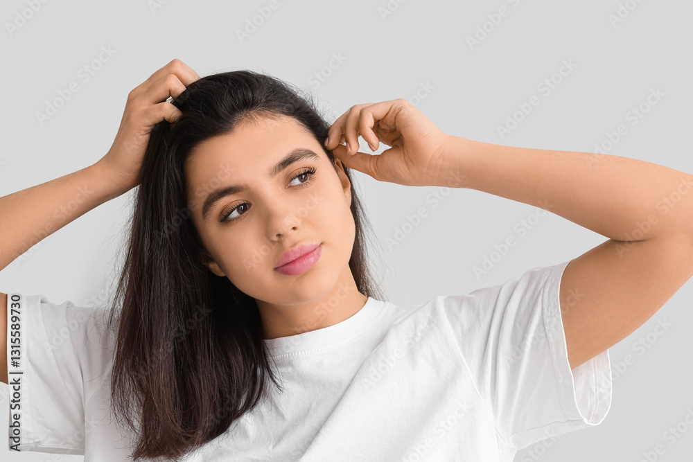 Young woman with dandruff problem examining her hair on white background Young woman with dandruff problem examining her hair on white background