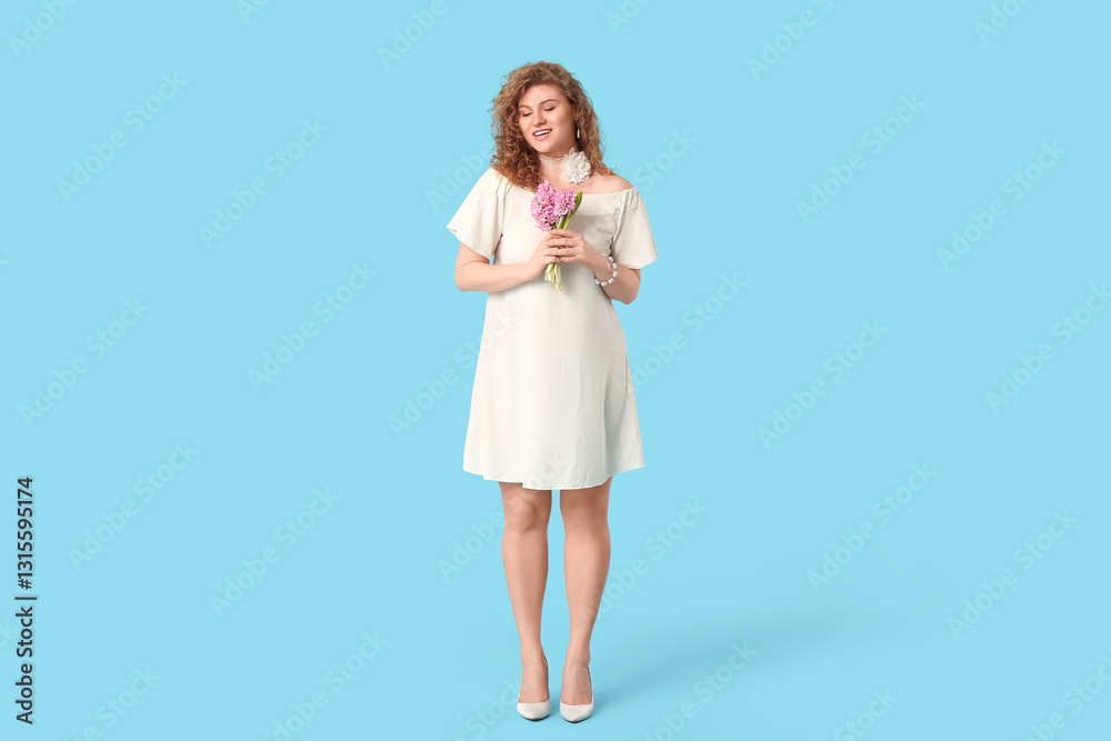Pretty young woman in stylish white dress with beautiful flowers on blue background Pretty young woman in stylish white dress with beautiful flowers on blue background