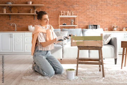 Young woman painting wooden...
