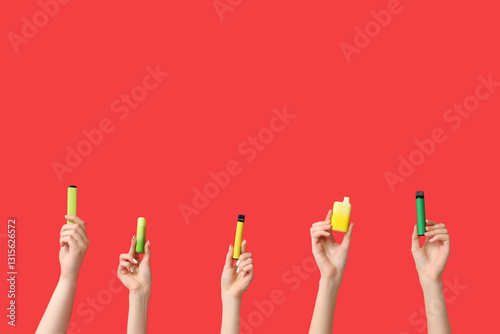 Many hands holding electronic cigarettes on red background