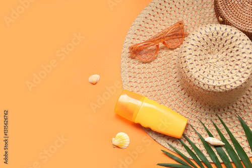 Beautiful composition with beach accessories and sunscreen on orange background
