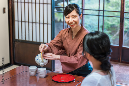 温泉旅館の客室でお茶を淹れる旅館スタッフ・仲居さんの女性
 photo