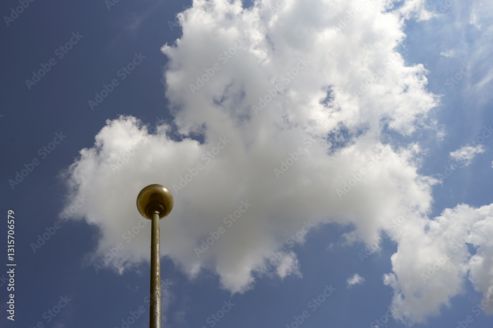 Streetlight Post Against a Blue Sky with White Clouds Streetlight Post Against a Blue Sky with White Clouds