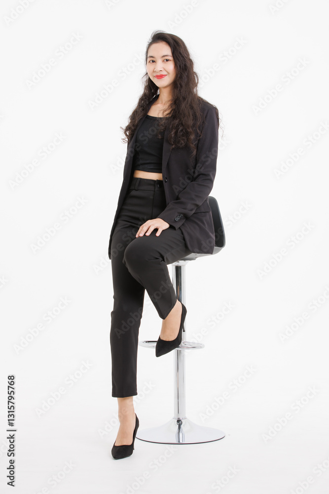 Fototapeta premium Portrait full body asian beautiful woman curly hair, wearing black suit, black long pants, model girl attractive confident, pose sitting on stool smiling look at camera on white background in studio.