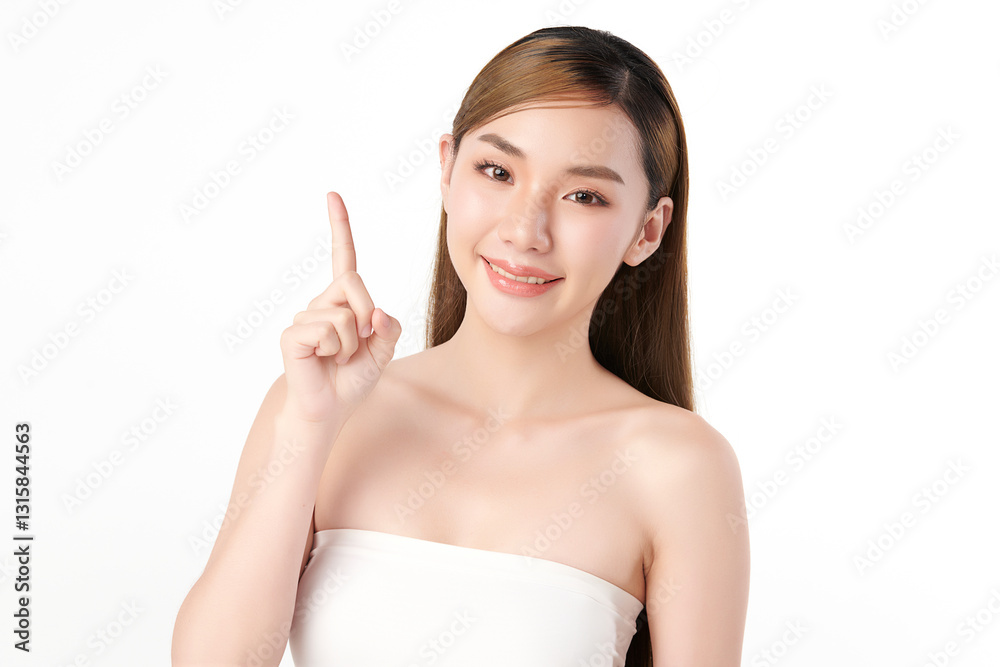 A beautiful Asian woman with clear, radiant skin is raising one finger against a white background. Skincare, beauty, and spa. A beautiful Asian woman with clear, radiant skin is raising one finger against a white background. Skincare, beauty, and spa.