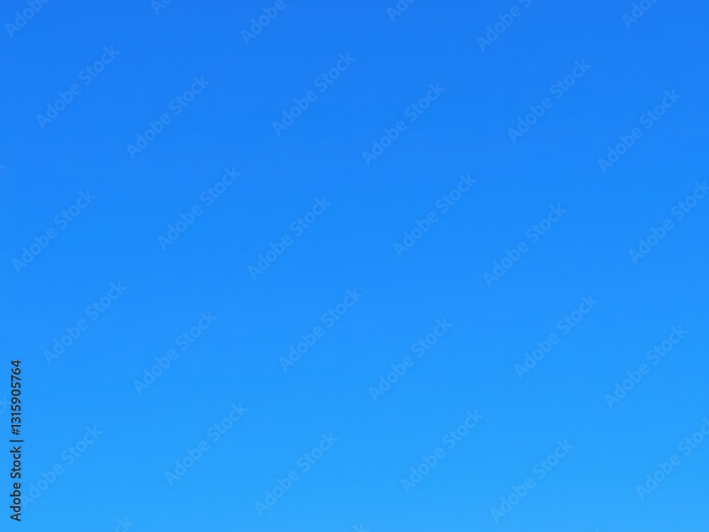 vast expanse of a clear blue sky with a smooth gradient of color. T