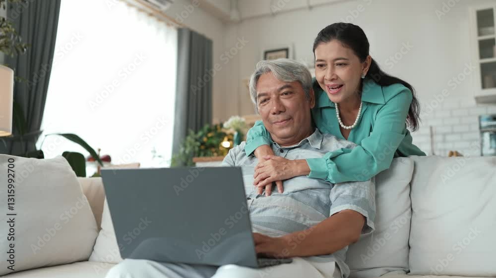 Senior businessman working at laptop while grandmother supporting him. Stressed elder man looking at financial chart or deceasing sales report from computer while elder woman hugging him. Myrmidon. Senior businessman working at laptop while grandmother supporting him. Stressed elder man looking at financial chart or deceasing sales report from computer while elder woman hugging him. Myrmidon.