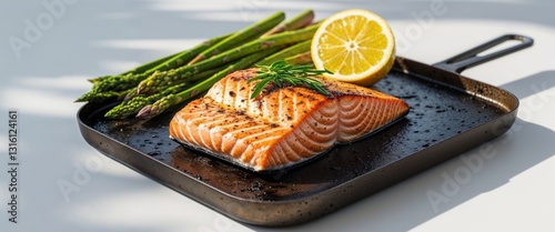 Grilled salmon fillet with asparagus and lemon on a griddle.