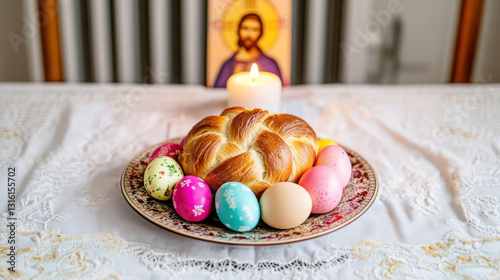 Festive easter table with bread, colored eggs, candle, and religious icon