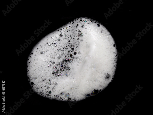 Liquid white foam from soap, shampoo or bath foam. Abstract soap bubbles. Set of soap bubbles. Separated soap bubbles on black background with contrasting texture.	
