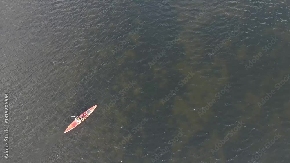 A lone kayaker paddles through the water off the coast of Florida. A lone kayaker paddles through the water off the coast of Florida.