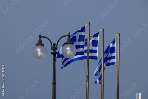 Greek flag waving in the wind on sunny day with blue sky
