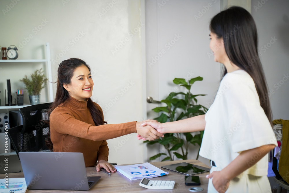 Business team of two executives working together using laptop in office. Happy young business woman manager showing project presentation to mature woman client, investor or partner at work meeting. Business team of two executives working together using laptop in office. Happy young business woman manager showing project presentation to mature woman client, investor or partner at work meeting.