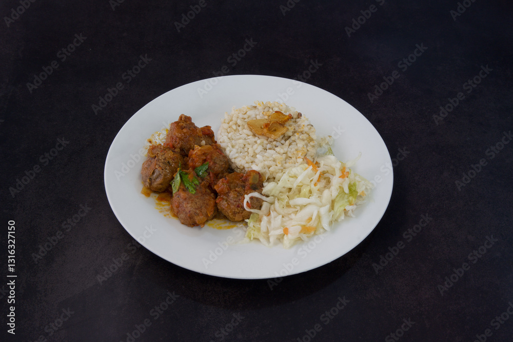 A plate of food with meat and rice on a dark background A plate of food with meat and rice on a dark background
