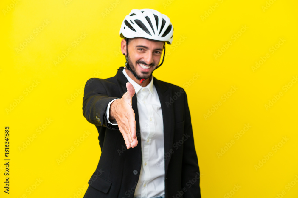 Business caucasian man with a bike helmet isolated on yellow background shaking hands for closing a good deal Business caucasian man with a bike helmet isolated on yellow background shaking hands for closing a good deal