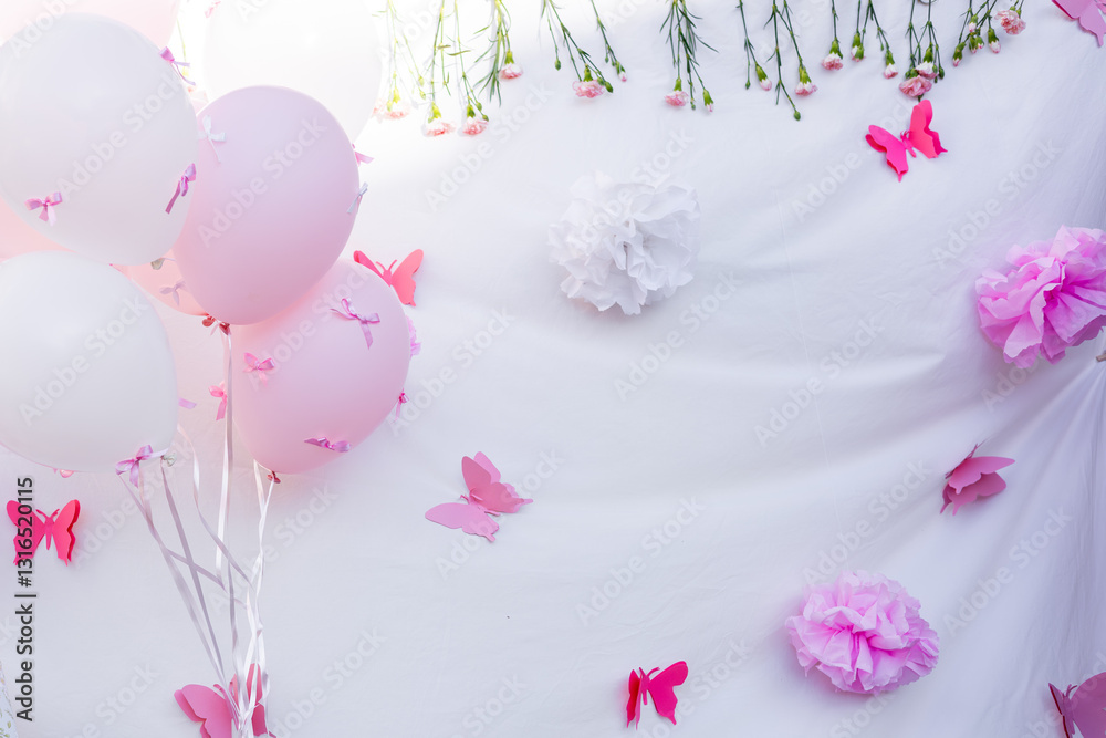 Decorative setup for a pink-themed celebration with balloons and flowers Decorative setup for a pink-themed celebration with balloons and flowers