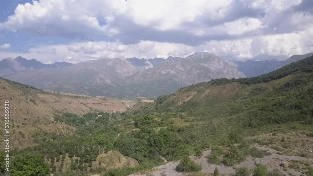 A drone over mountains covered with greenery and bushes. Cloudy summer day A drone over mountains covered with greenery and bushes. Cloudy summer day