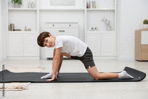 Boy doing exercise on fitness mat at home. Sport activity