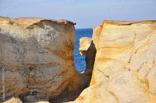 The coast of red stones on the Barents Sea, patterns on the rocks.