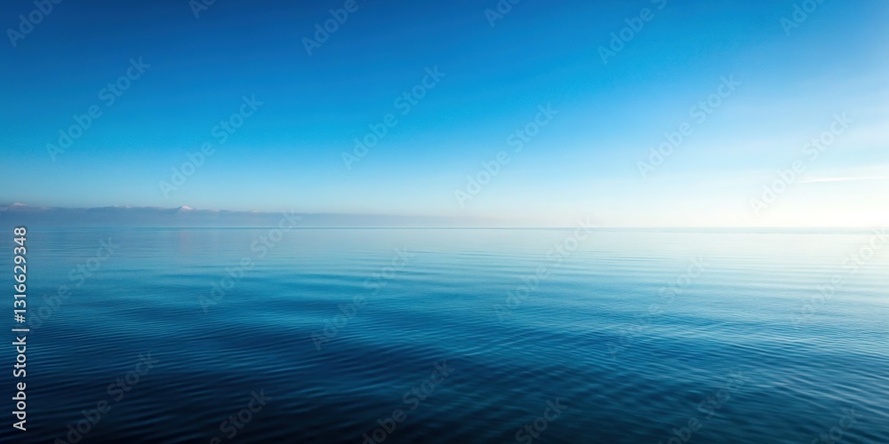 Obraz premium Minimalist Foggy Seascape: Calm Ocean Reflecting Blue Sky