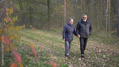Elderly couple walki in the park on an autumn day. People over 60, aging youthfully