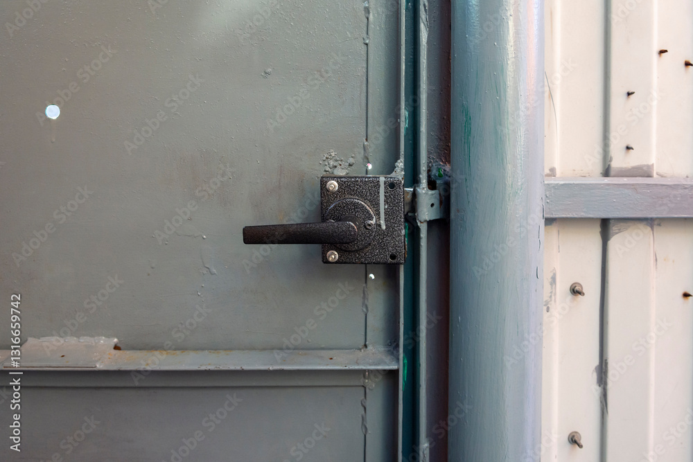 winter cool morning, door handle and lock on metal door painted in gray, close-up winter cool morning, door handle and lock on metal door painted in gray, close-up