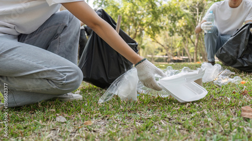Photography Close-up of a volunteer picking up trash, promoting a cleaner environment