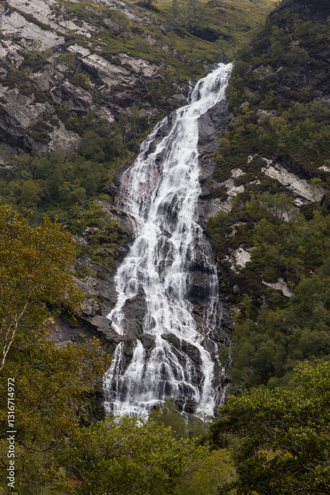 Obraz premium Steall Waterfall, a breathtaking natural wonder in the Scottish Highlands, from rugged cliffs into a lush valley. Trekking adventure leads to panoramic views, where embrace the wild untouched nature.