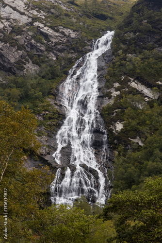 Steall Waterfall, a breathtaking natural wonder in the Scottish Highlands, from rugged cliffs into a lush valley. Trekking adventure leads to panoramic views, where embrace the wild untouched nature.