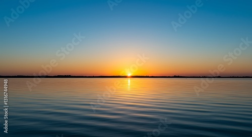 Sunset Over Calm Water Reflecting Orange Sky in a Tranquil Scene