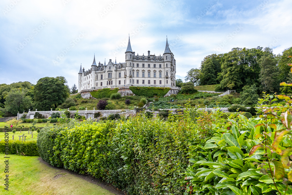 Fototapeta premium Dunrobin Castle, fairy-tale gem overlooking North Sea, offers breathtaking gardens, exquisite summer blooms. A masterpiece of elegance, lush landscapes meet historic charm, unfold on manicured lawns