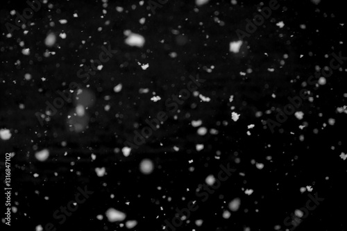 Texture of natural falling snow on black background.