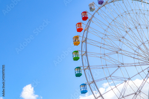 Colourful ferris wheel against a blue sky.