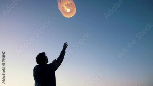 Young Man Releasing Stress Labeled Paper Lantern into Sunset Sky Emotional Release Concept 4K Video
