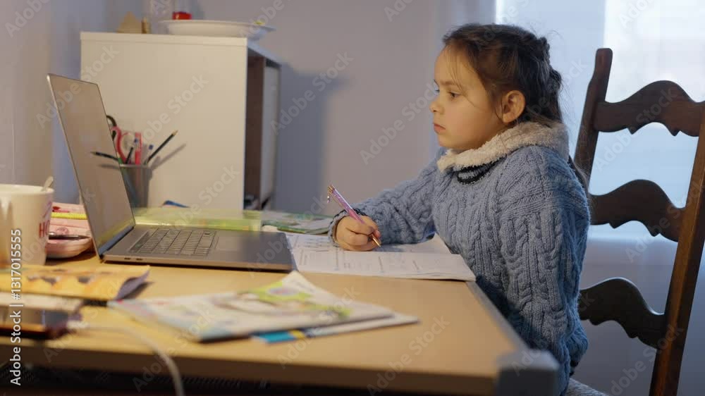 A concentrated and focused child is actively participating in virtual education while using a laptop at home. A Child Actively Engaged in Online Learning from the Comfort of Their Home Environment A concentrated and focused child is actively participating in virtual education while using a laptop at home. A Child Actively Engaged in Online Learning from the Comfort of Their Home Environment