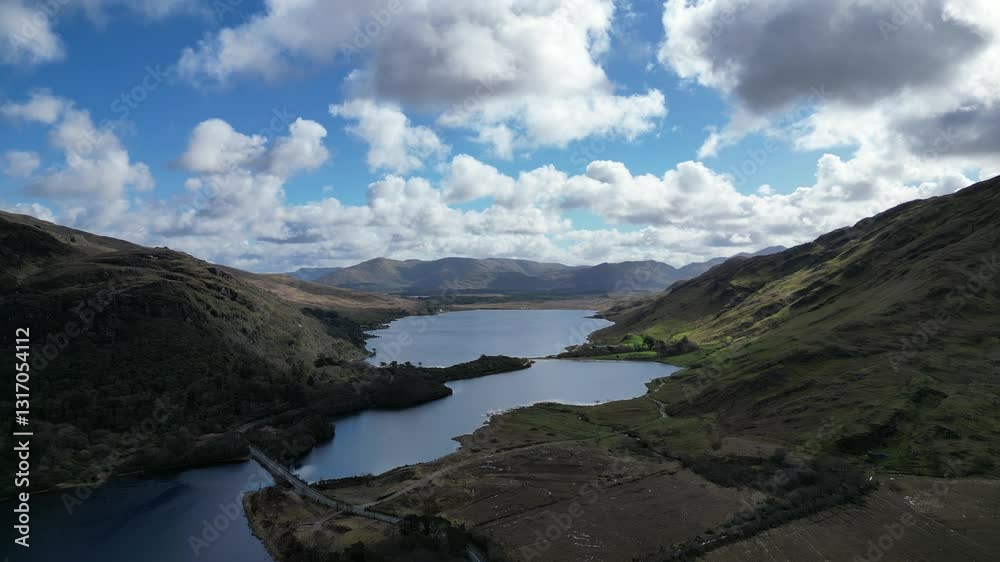Serene lake surrounded by majestic mountains and drifting clouds in Ireland Serene lake surrounded by majestic mountains and drifting clouds in Ireland