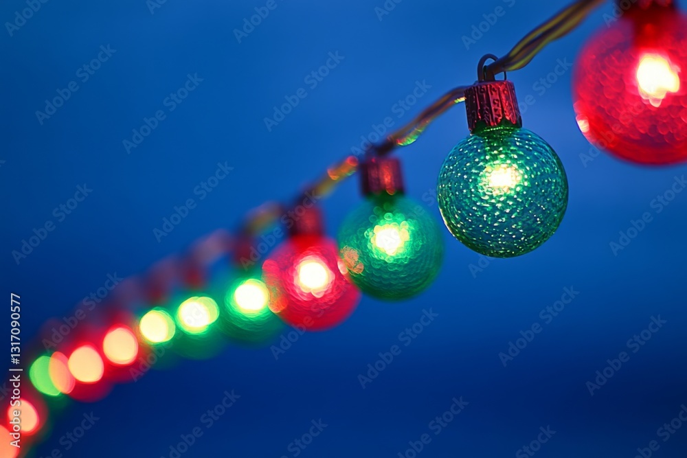 Fototapeta premium Festive row of red and green Christmas lights on eaves against dark blue sky – joyful New Year’s Eve atmosphere