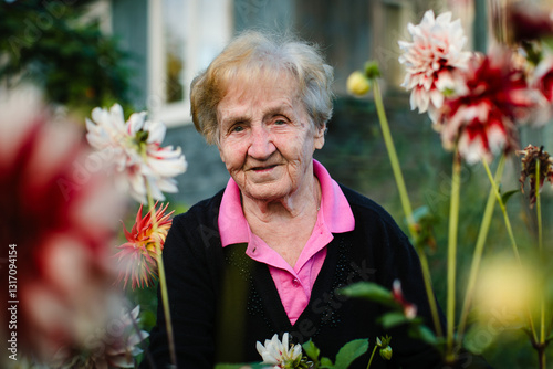 Obraz na płótnie A portrait of an elderly woman in a garden surrounded by blooming flowers, radiating warmth and serenity in a natural setting. w salonie