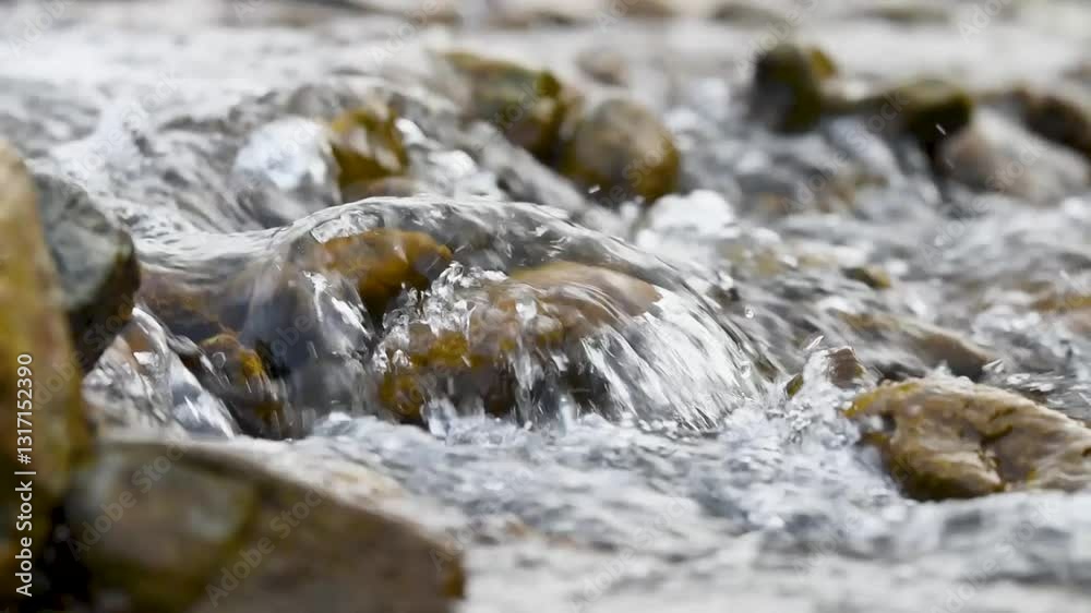 Water gurgles over stones in mountain creek close up, detail from stream with clear water splashing Water gurgles over stones in mountain creek close up, detail from stream with clear water splashing