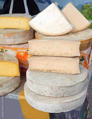 dairy stall selling aged and fresh cheese in round shapes