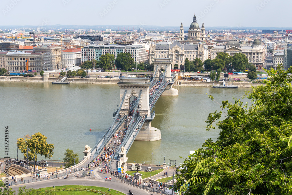 Obraz premium The Pest side of Budapest with St. Stephen's Basilica, the Chain Bridge open to pedestrian tourists, and the Danube