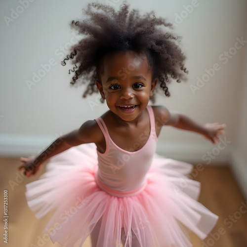 Niña pequeña africana vestida de bailarina y feliz photo