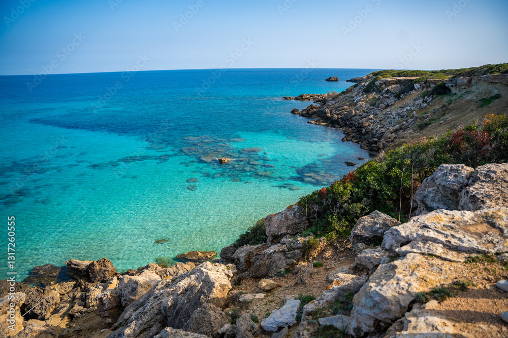 Coastline with a sandy beach and rocky shores near the northeasternmost cape of Northern Cyprus. Crystal-clear waters of a blue lagoon and the untouched beauty of the Mediterranean Coastline with a sandy beach and rocky shores near the northeasternmost cape of Northern Cyprus. Crystal-clear waters of a blue lagoon and the untouched beauty of the Mediterranean