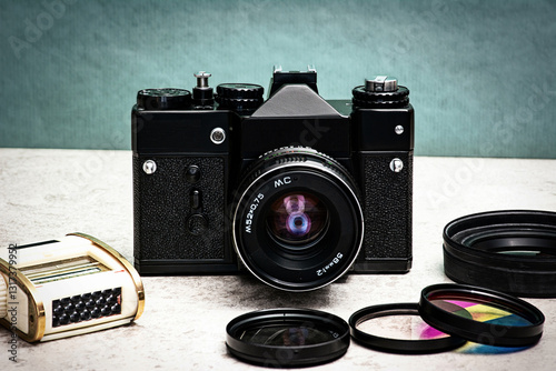 A nostalgic manual SLR camera for films with various filters and a light meter.