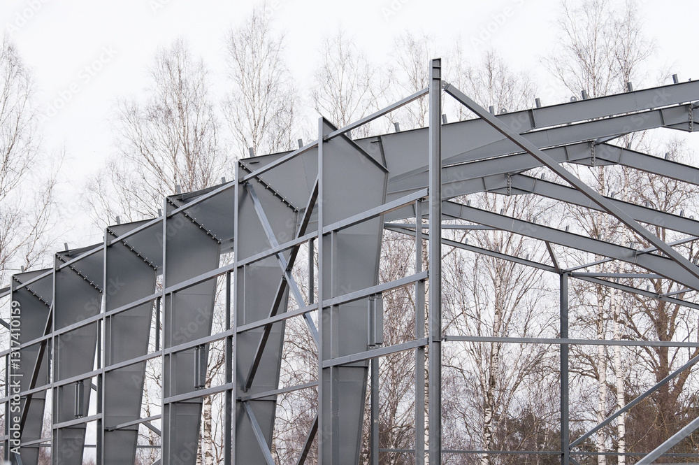Metal construction, in the photo the structure of the building frame made of metal beams against the background of a gray sky Metal construction, in the photo the structure of the building frame made of metal beams against the background of a gray sky