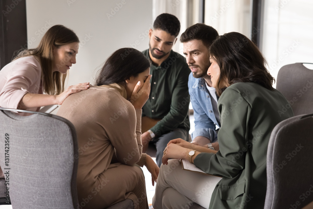 Fototapeta premium Diverse people listen to young crying woman sharing her life problems during social community meeting seated in circle, offering comfort and understanding, fostering safe space for honesty and support