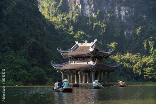 Tourists rowing boats visiting temple on Trang An Scenic Landscape Complex, Ninh Binh Province, Vietnam
