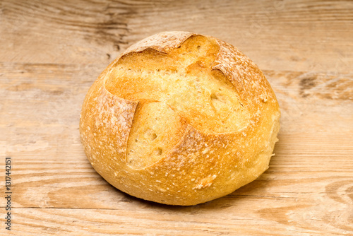 Petit pain rond posé sur une table en bois